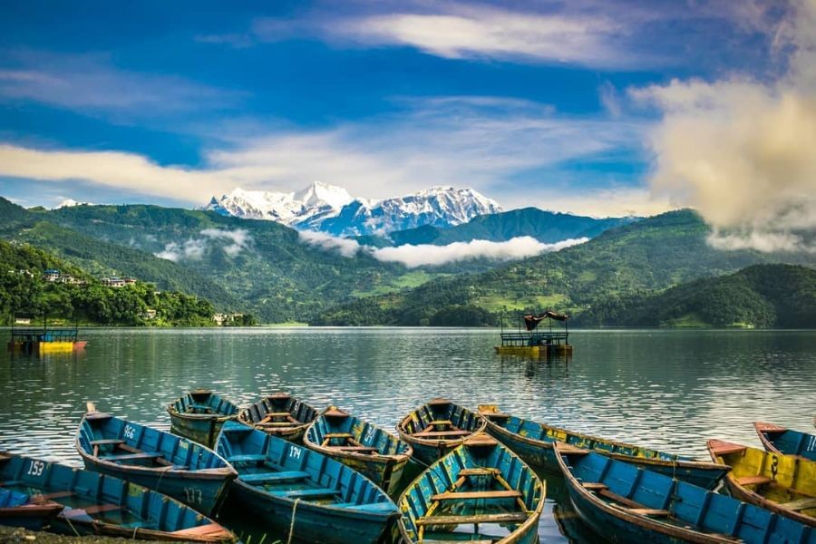 Colorful wooden boats on Phewa Lake with Annapurna mountains in background, Pokhara